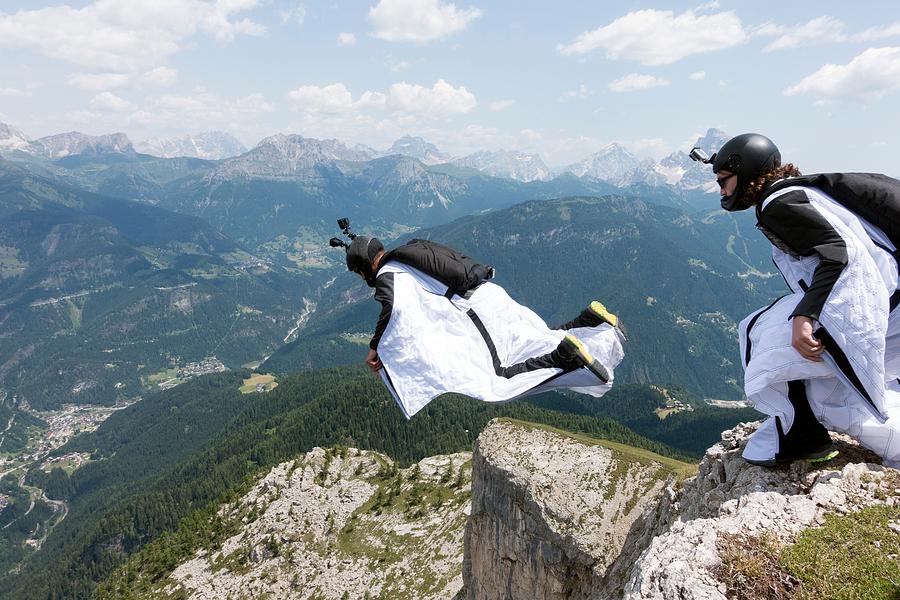 Two male BASE jumpers exiting from mountain top, Dolomites, Italy Photograph by Oliver Furrer