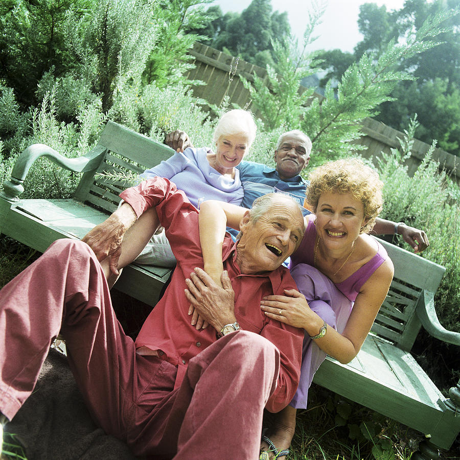 Two mature couples sitting outdoors, smiling Photograph by Patrick Sheandell OCarroll