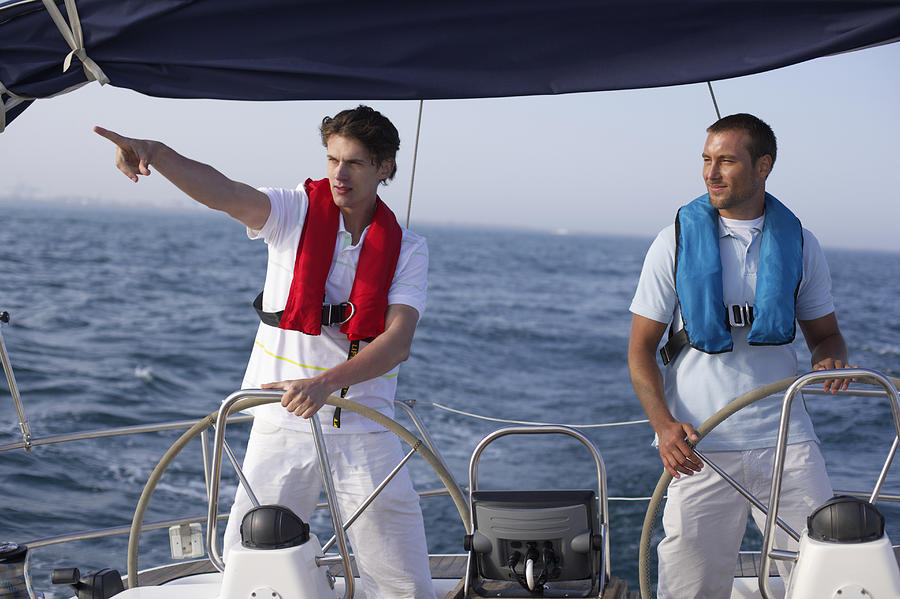 Two men steering a boat Photograph by Stock4b-rf