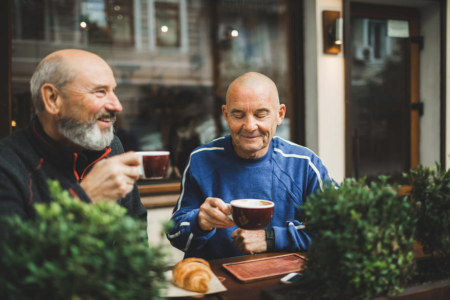 Two old age senior friends drinking coffee in cafe on outside terrace. Laughing and talking. Young at heart Photograph by Oleg Breslavtsev