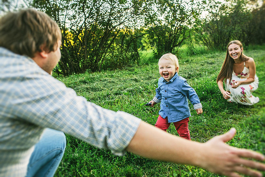 Two Parents With Little Toddler Son 1 Year Old Playing Outdoors On A Sunny Day In Countryside On Green Grass Photograph by With love of photography