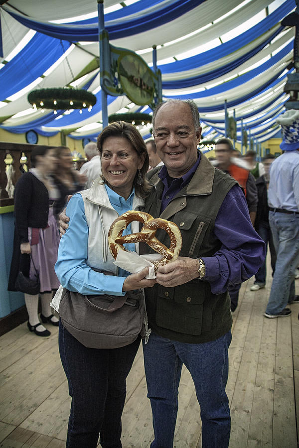 Two people holding a pretzel inside one of the Tents at the Beer Fest Photograph by ©fitopardo
