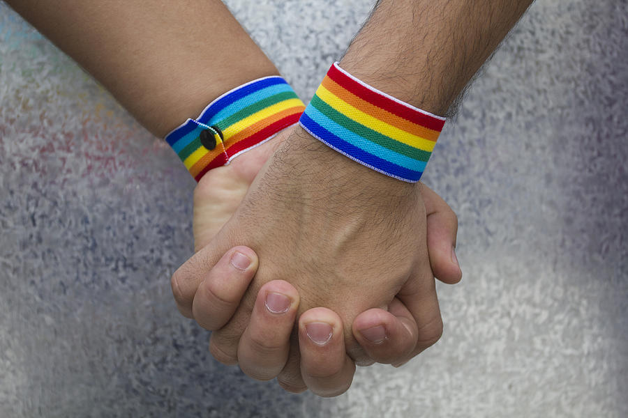 Two people holding hands and wearing rainbow bracelets Photograph by Brasil2