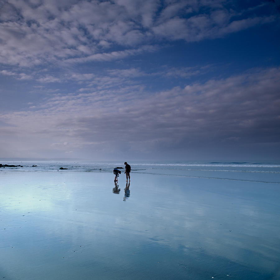 Two people on beach at dusk Photograph by David Henderson