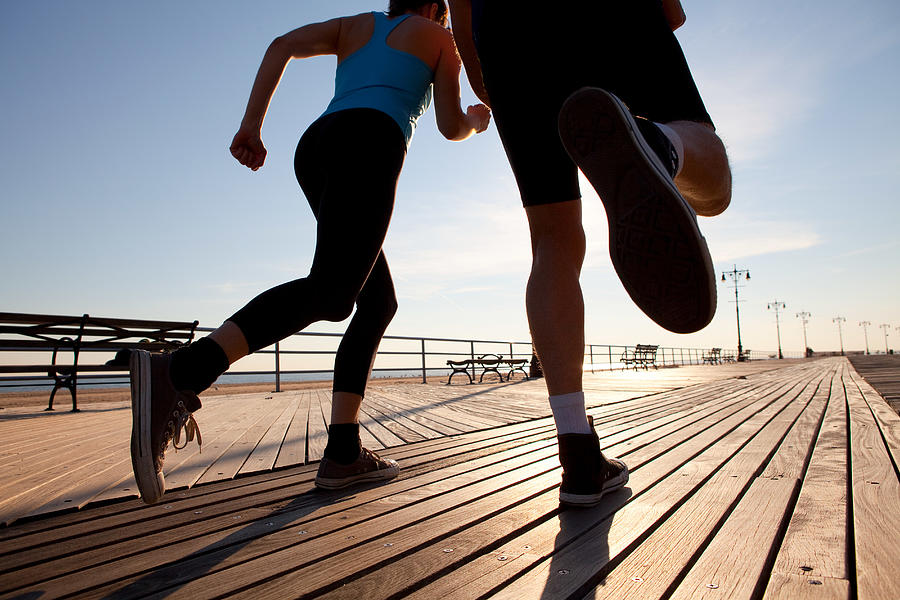 Two people running on promenade Photograph by Image Source