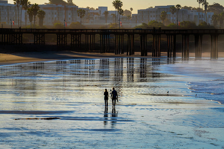 Two people walking on beach Photograph by Dan Friend
