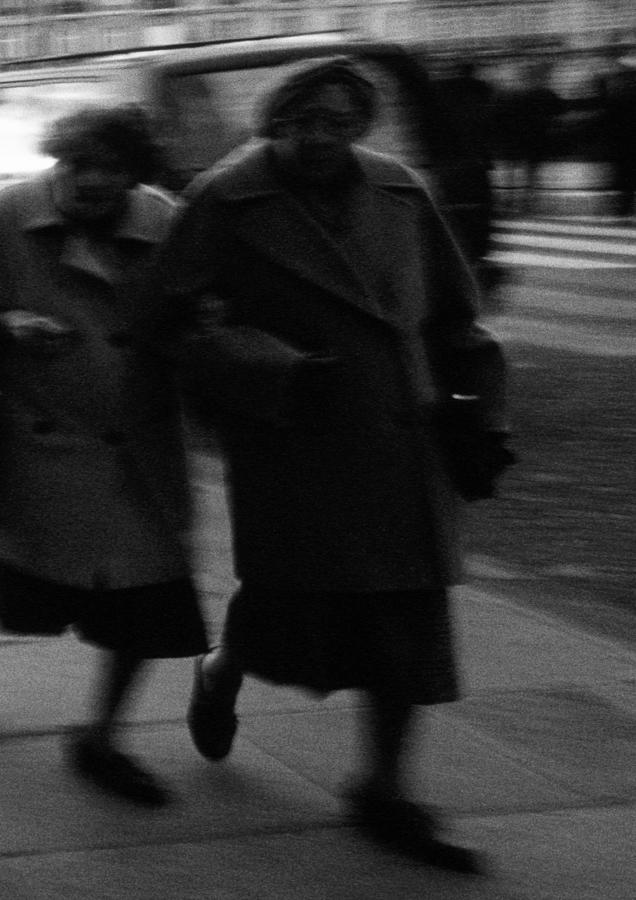 Two people walking on pavement , blurred, b&w Photograph by Frederic Cirou