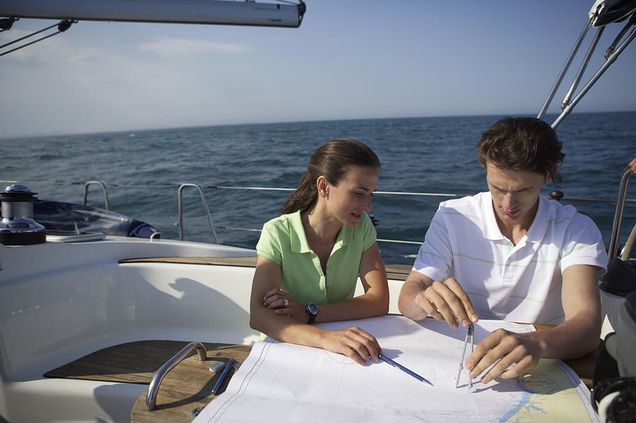 Two people working on a sea chart Photograph by Stock4b-rf