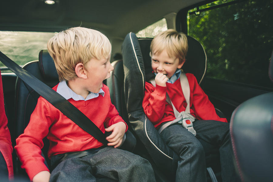 Two school children in the car Photograph by Sally Anscombe