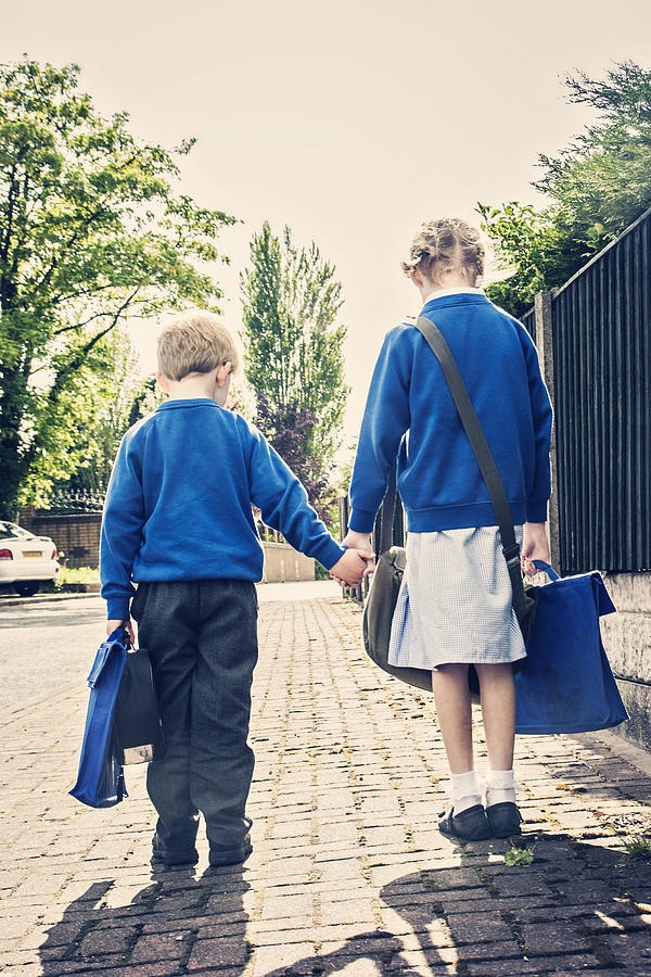 Two school children on their way to school Photograph by Sally Anscombe
