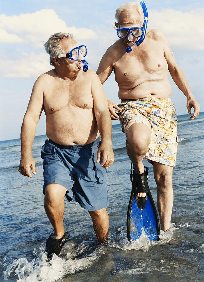 Two Senior Men in Scuba Masks and Flippers Wading in the Sea Photograph by Digital Vision.