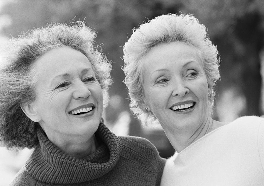 Two senior women smiling, portrait, B&W. Photograph by Teo Lannie