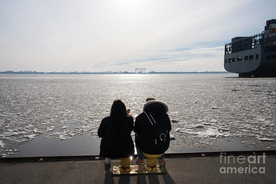 two silhouettes on the banks of the frozen Elbe Photograph by Marina Usmanskaya