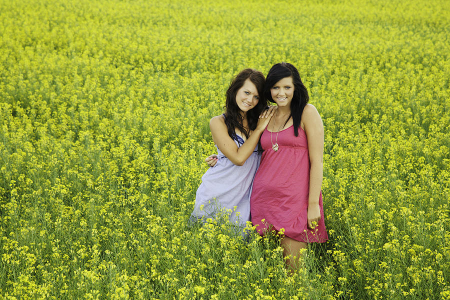 Two Sisters Standing in Canola Field Photograph by Digitalhallway