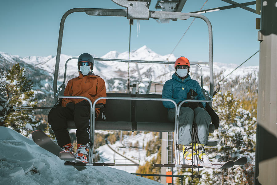 Two Skiers With Mouth Nose Mask On Chair Lift Photograph by Amriphoto