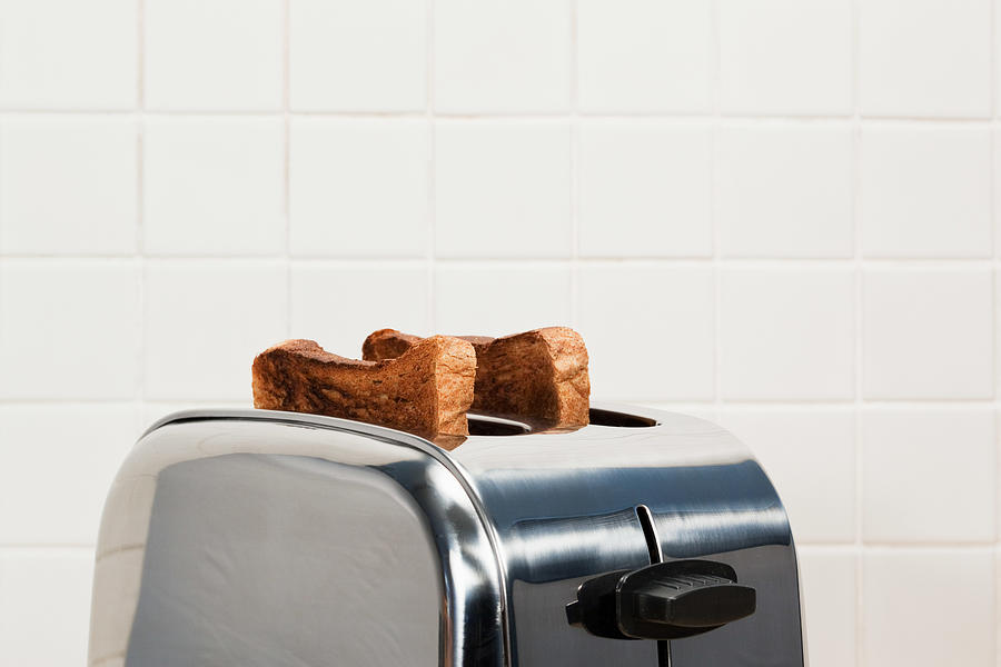 Two slices of toast in toaster Photograph by Image Source