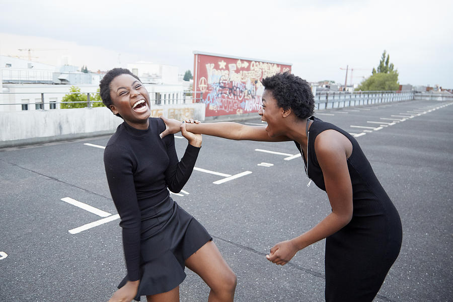 Two teenage girls laughing together Photograph by Chris Tobin