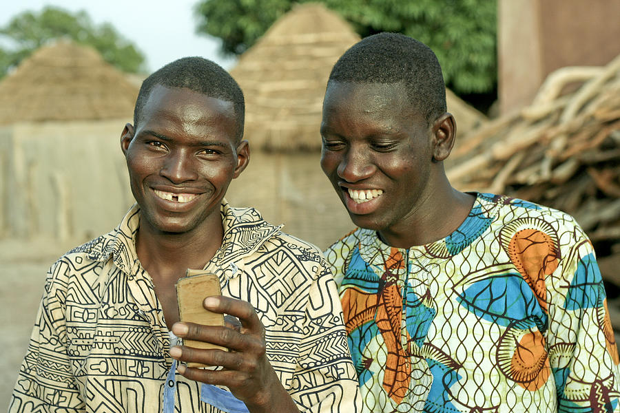 Two villagers with a mobile phone Photograph by Commerceandculturestock