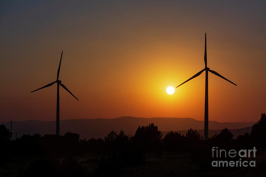 Two windmills facing the sun at sunset Photograph by Vicente Sargues