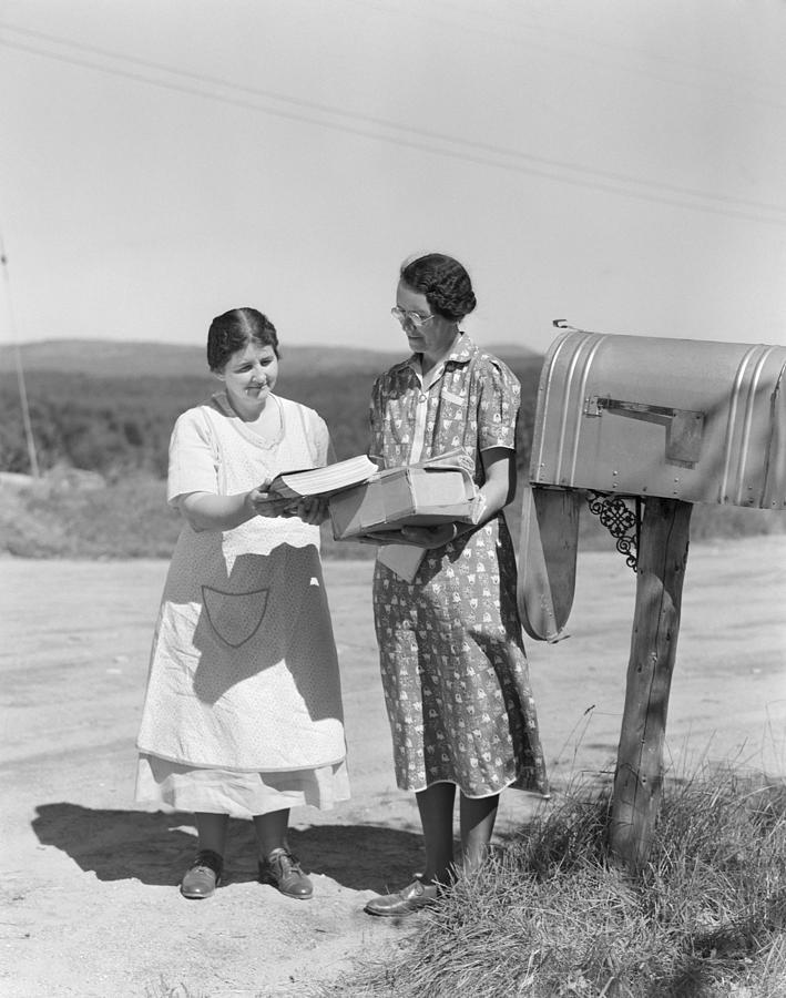 Two women collect mail from country mailbox. Photograph by H. Armstrong Roberts