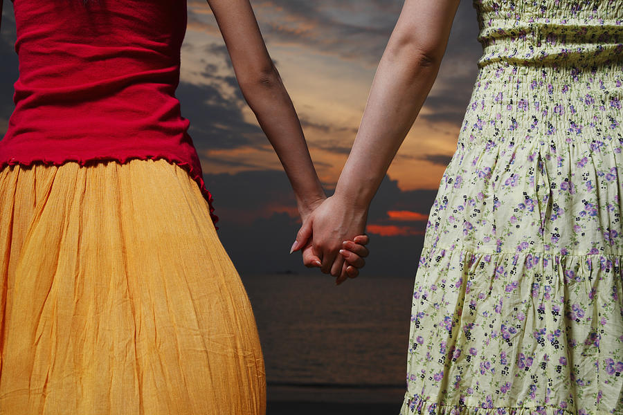 Two women holding hands, outdoors, mid section Photograph by Ultra.f