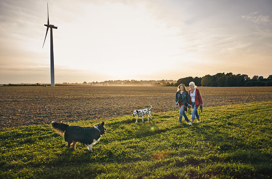 Two women on a dog walk in the countryside Photograph by Uwe Krejci
