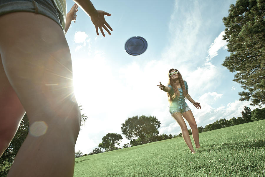 Two women playing game of Frisbee in park Photograph by Crotography