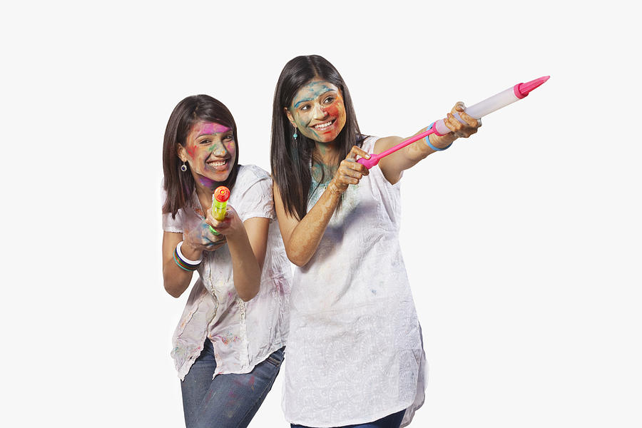 Two women playing holi Photograph by Hemant Mehta