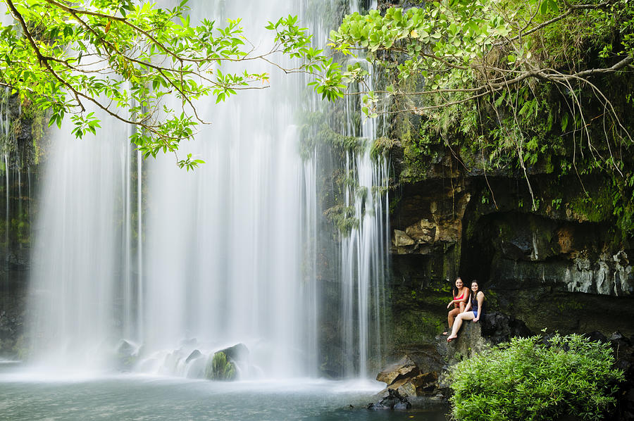 Two women relaxing next to a waterfall. Photograph by OGphoto