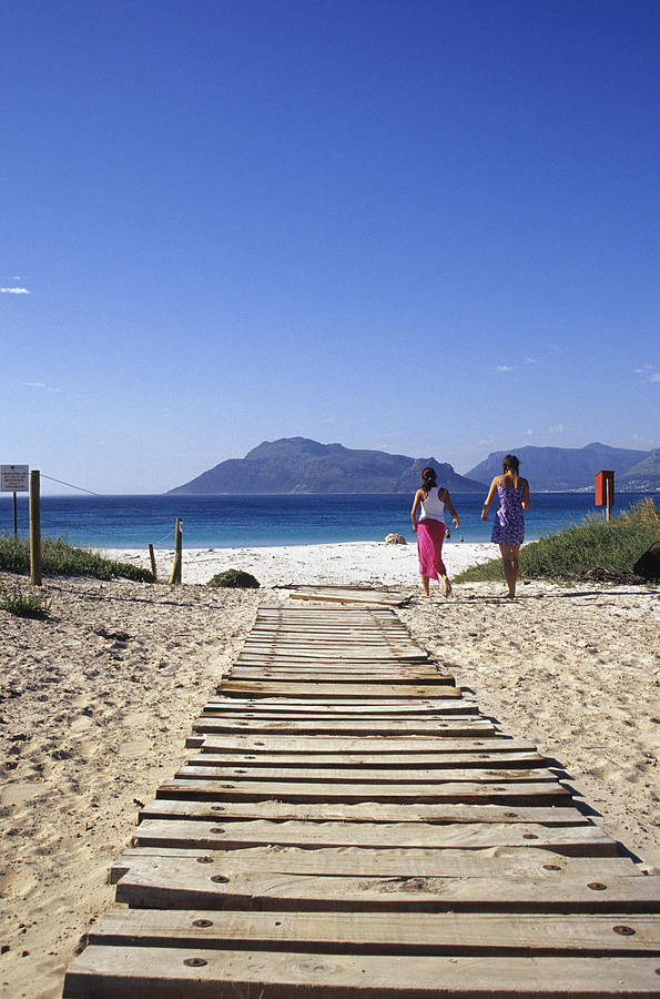 Two women walking towards beach, South Africa Photograph by Mel Stuart