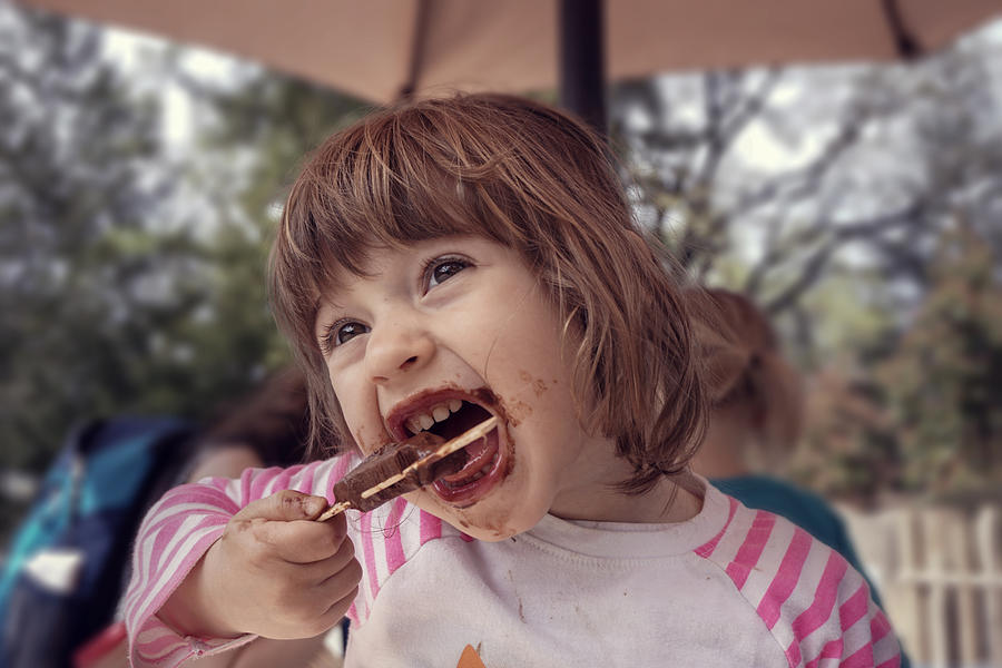 Two-year old girl eating a popsicle Photograph by Melinda Podor
