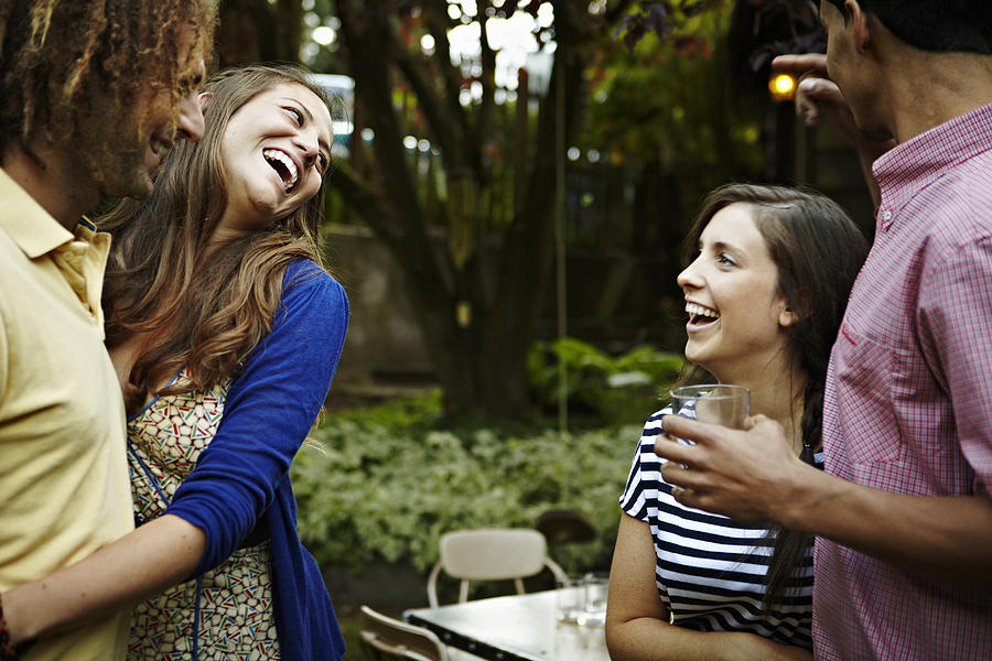 Two young couples in backyard garden laughing Photograph by Thomas Barwick