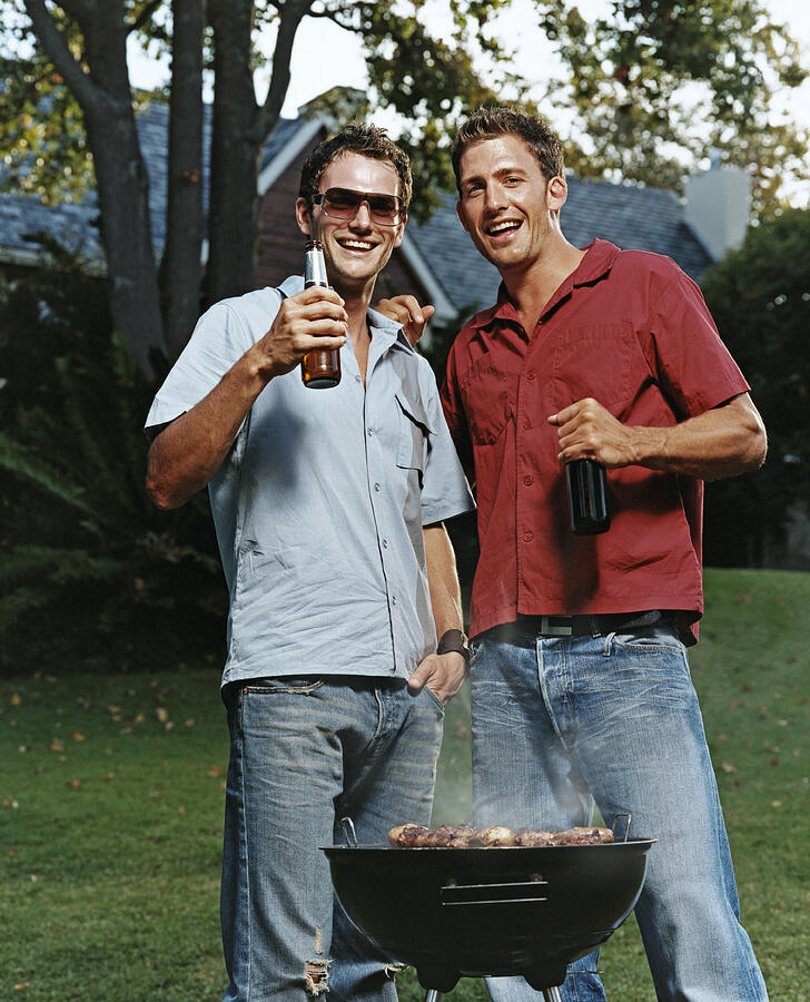 Two Young Men in a Garden With a Beer and Barbeque Photograph by Digital Vision.