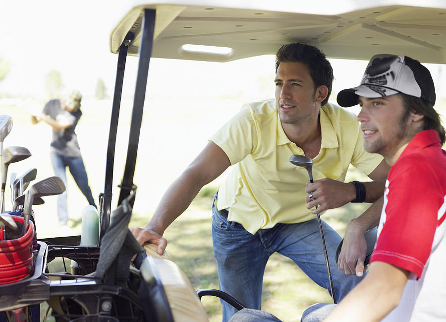 Two Young Men Together on a Golf Buggy Photograph by Digital Vision.