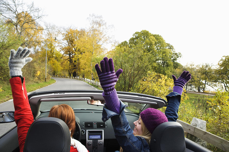 Two young women driving a cabriolet an autumn day Sweden. Photograph by Plattform