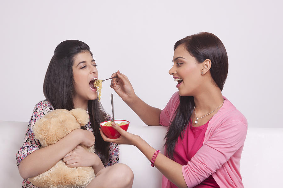 Two young women eating noodles Photograph by Sudipta Halder