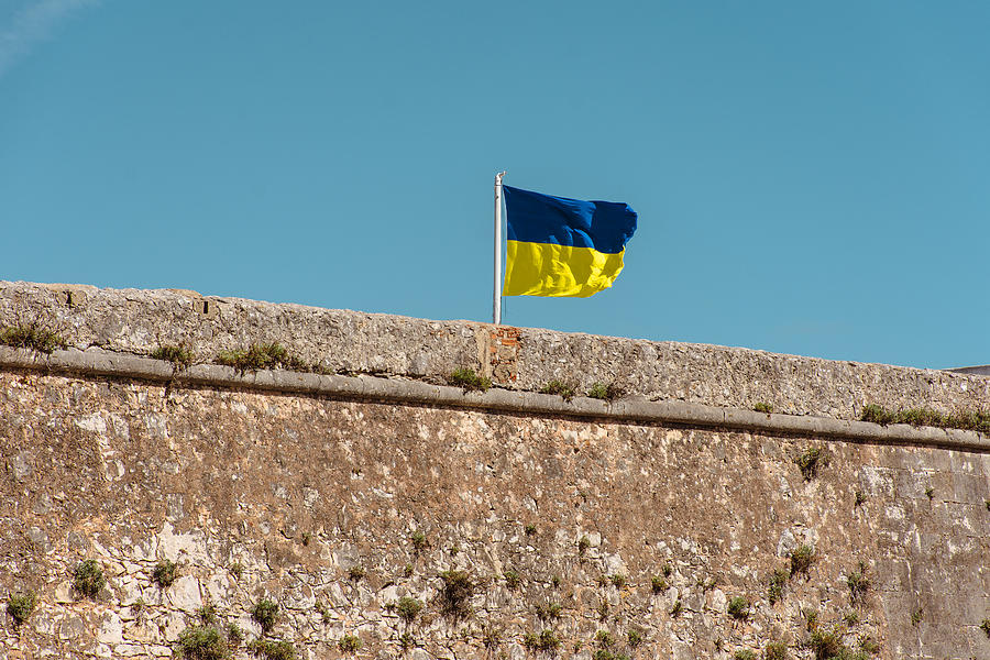 Ukrainian flag flying over the wall against blue sky Photograph by Gabriel Mello