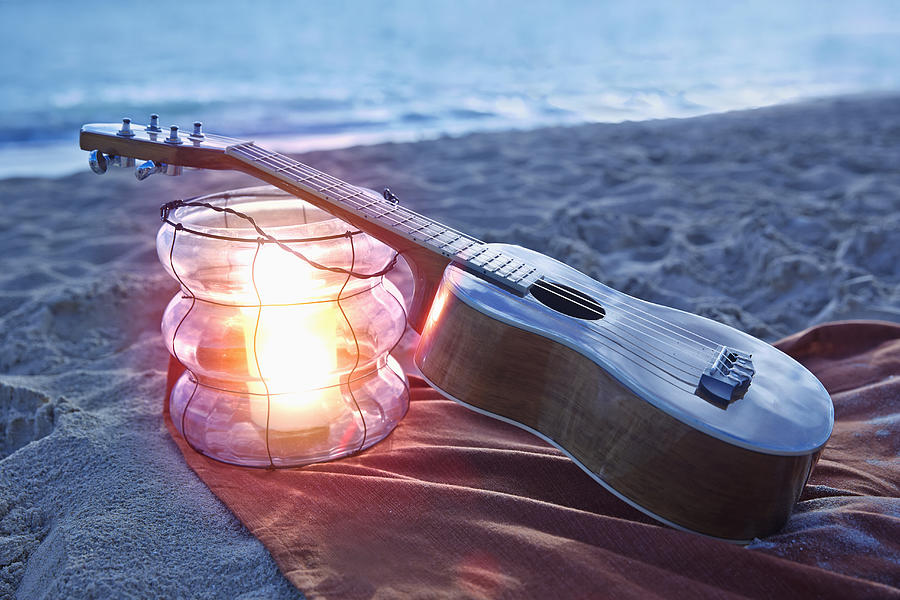 Ukulele resting on lantern on beach Photograph by Colin Anderson Productions pty ltd