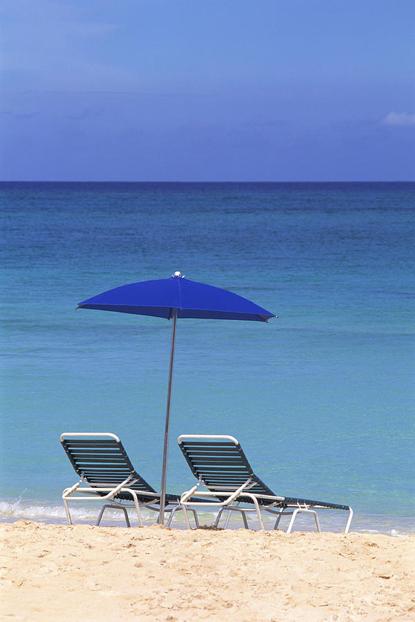 Umbrella and lounge chairs on beach Photograph by Comstock Images