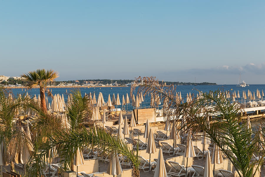 Umbrellas and beach chairs on the beach, Cannes, French Riviera Photograph by Jean-Marc PAYET Umbrellas and beach chairs on the beach, Cannes, French Riviera Photograph by Jean-Marc PAYET