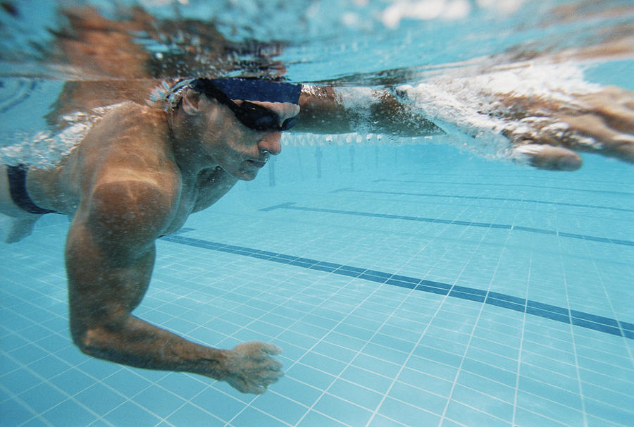 Underwater Shot of a Young Man Swimming in a Pool Photograph by Digital Vision.