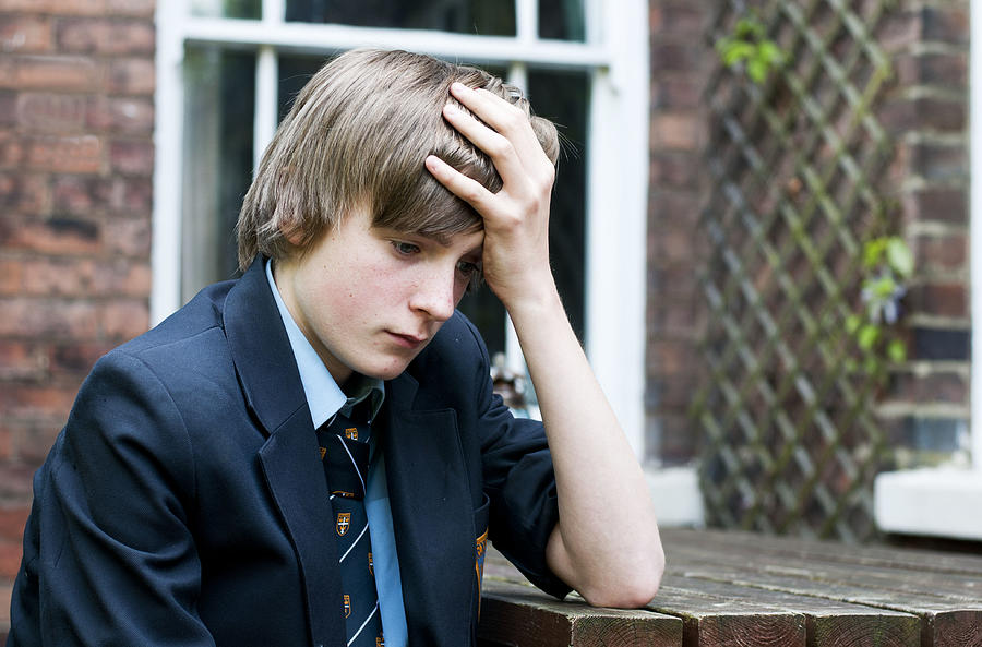 Unhappy teenage school boy Photograph by Deborah Faulkner