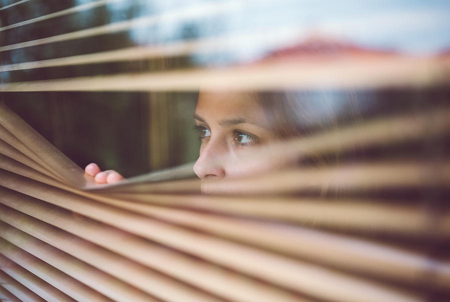 Unhappy woman peeks through the window Photograph by Martin-dm