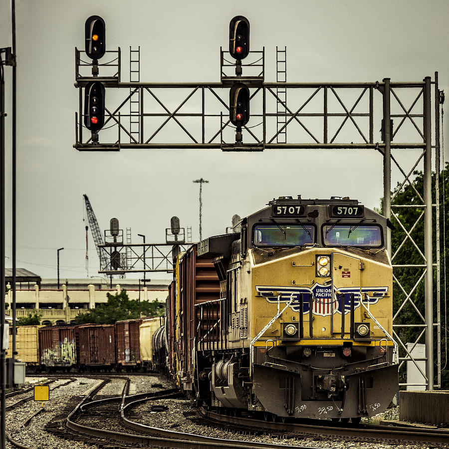 Union Pacific (UP) freight train passing under city signal gantry Photograph by BeyondImages