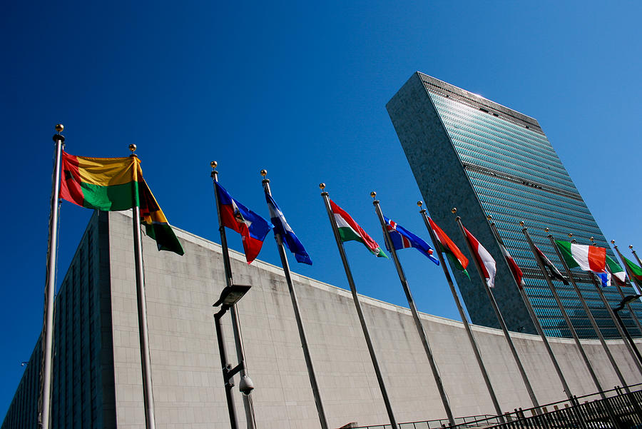 United Nations Headquarters with waving flags in New York, USA Photograph by Drazen_