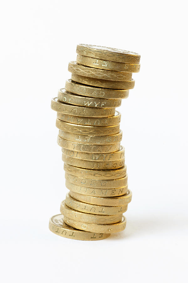 Unstable stack of one pound coins about to topple Photograph by Rosemary Calvert