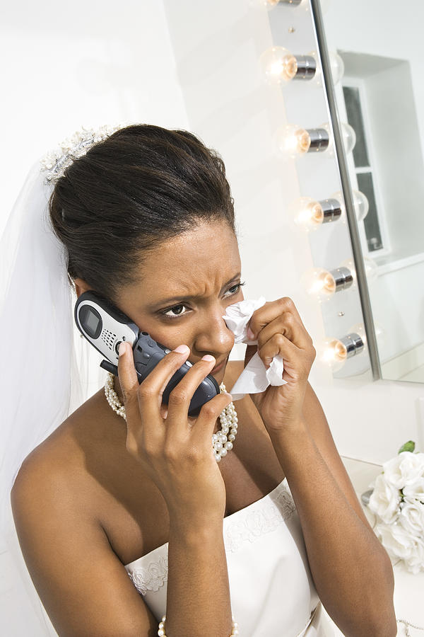 Upset bride using cell phone Photograph by Jupiterimages
