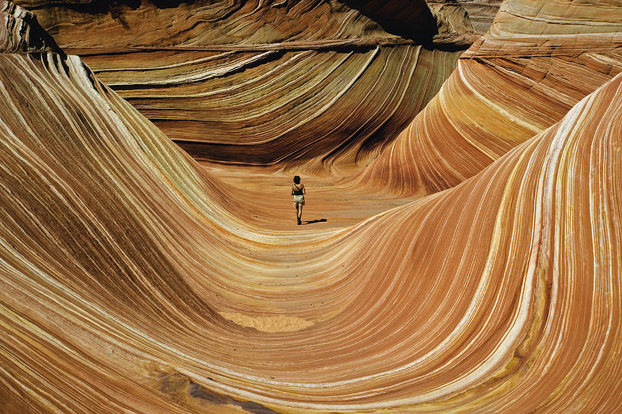 USA, Arizona/Utah border, woman walking across The Wave, rear view Photograph by Adam Jones