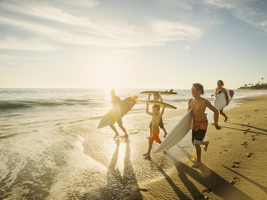 USA, California, Laguna Beach, Family with three children (6-7, 10-11, 14-15) with surfboards on beach Photograph by Erik Isakson
