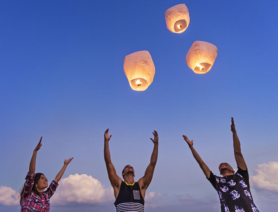 USA, Florida, Jupiter, Young people with illuminated lanterns at sunset Photograph by Daniel Grill